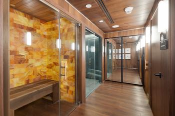 A hallway with a bench and a glass door.